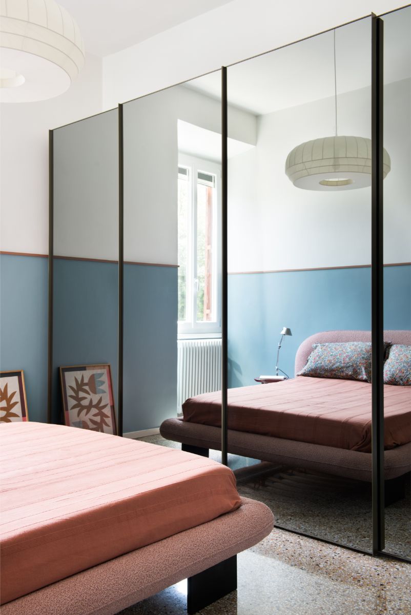 Hlavná spálňa s posteľou v ružovej farbe a skriňou so zrkadlovými dverami.