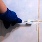 Detail na čistenie škáry medzi obkladačkami zubnou kefkou.