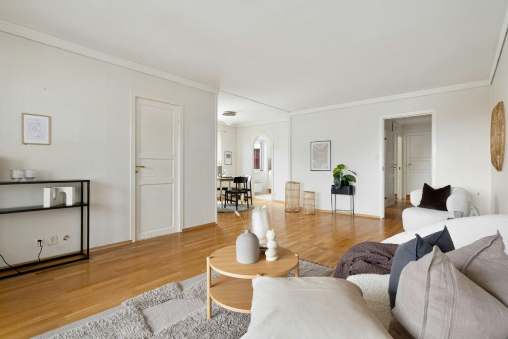 Otvorená denná zóna s obývacou časťou a dverami do ďalšej miestnosti.