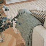 Detaily interiéru v boho štýle s pohovkou, eukalyptom a plédom v odtieni Warm Eucalyptus od Valspar.