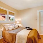 Útulná spálňa s hnedou prešívanou prikrývkou a stenami v krémovom odtieni Melodious Ivory od Dutch Boy Paints.