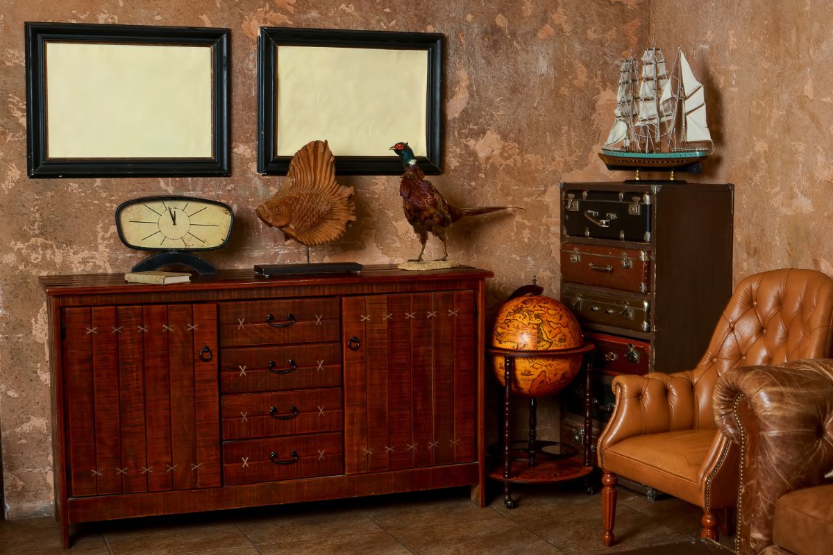 Vintage pracovňa s koženým kreslom, drevenou komodou a patinovanými stenami v odtieni Warm Mahogany od Glidden.