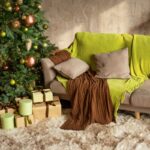 Vianočná obývačka s ozdobeným stromčekom, huňatým kobercom a vankúšmi vo farbe Universal Khaki od Sherwin-Williams.