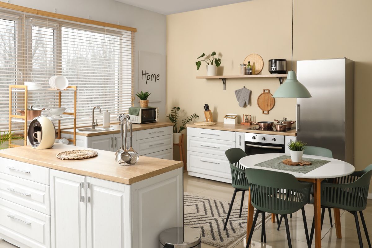 Svetlá kuchyňa s bielymi skrinkami, drevenou linkou a stenou v teplom béžovom odtieni Epernay od C2 Paint.