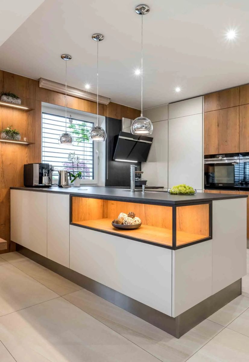 Moderná kuchynská linka s bielymi a drevnými skrinkami a čiernou pracovnou doskou.