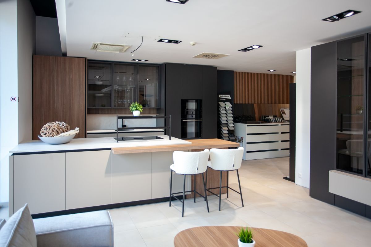 Moderná bielo-čierna kychynská linka so skrinkou s tmavého dreva.