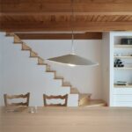 Pohľad cez drevený tradičný stôl na schody na poschodie.