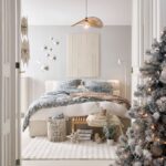 Svetlá spálňa so snehovo bielym kobercom, posteľou s modro-bielymi vzormi a moderným slameným tienidlom.