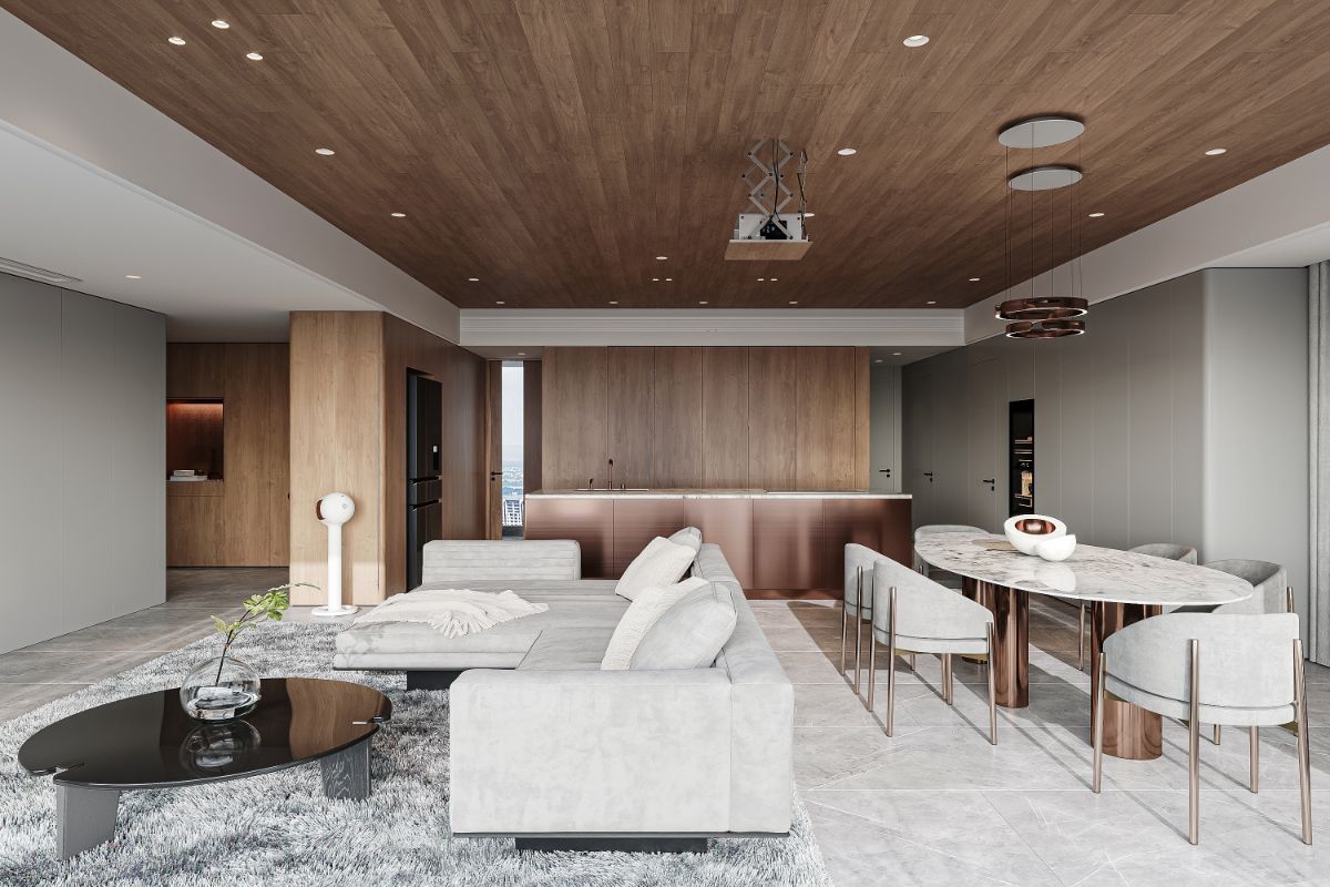 Luxusný otvorený priestor s dreveným stropom, sivou sedačkou, kuchyňou s medenými prvkami a mramorovým jedálenským stolom.