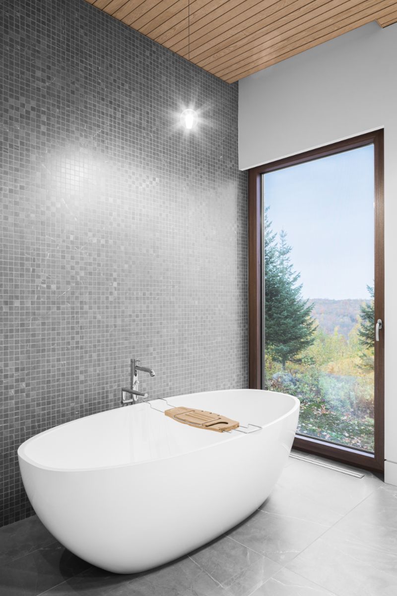 Vaňa s nádherným výhľadom na okolie prislúcha k hlavnej spálni na prízemí. Z druhej strany sa nachádza dvojité umývadlo aj vstup do toalety.