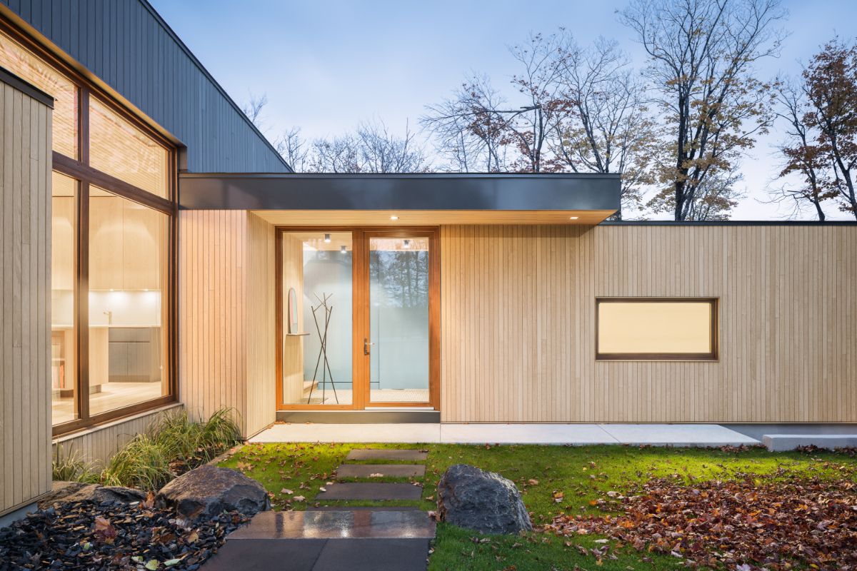 Do má len jednoduchú fasádu, z  časti obloženú svetlým drevom