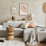 Miestnosť s hlinenými stenami, svetlou sedačkou a doplnkami v prírodných odtieňoch.