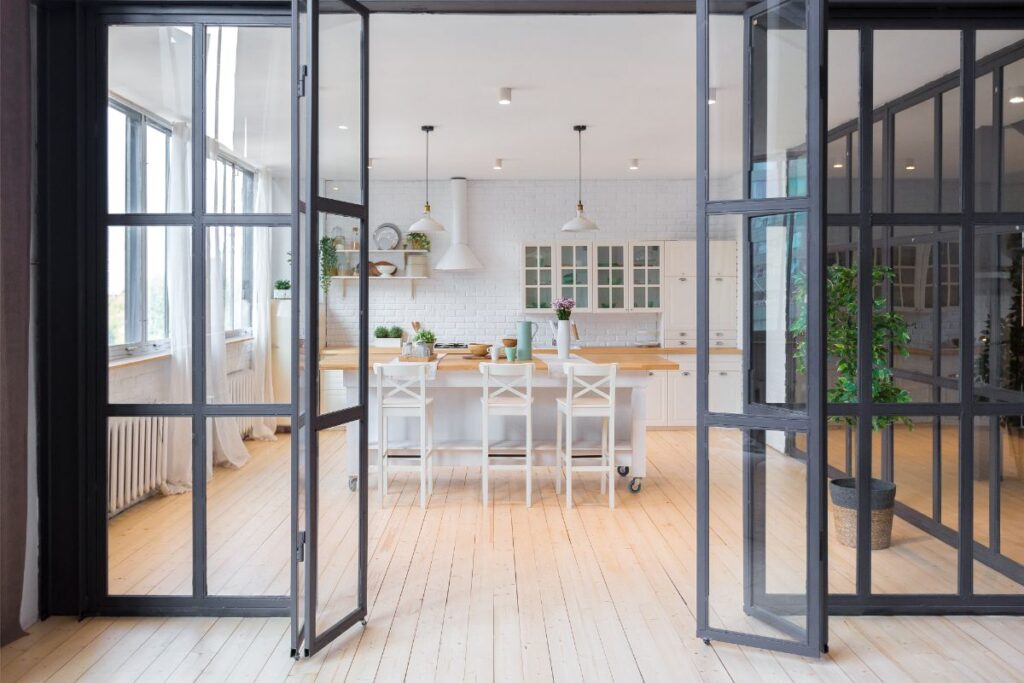 Pohľad cez presklené skladacie dvere do jedálne a kuchyne.
