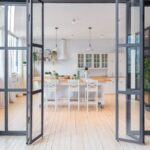 Pohľad cez presklené skladacie dvere do jedálne a kuchyne.