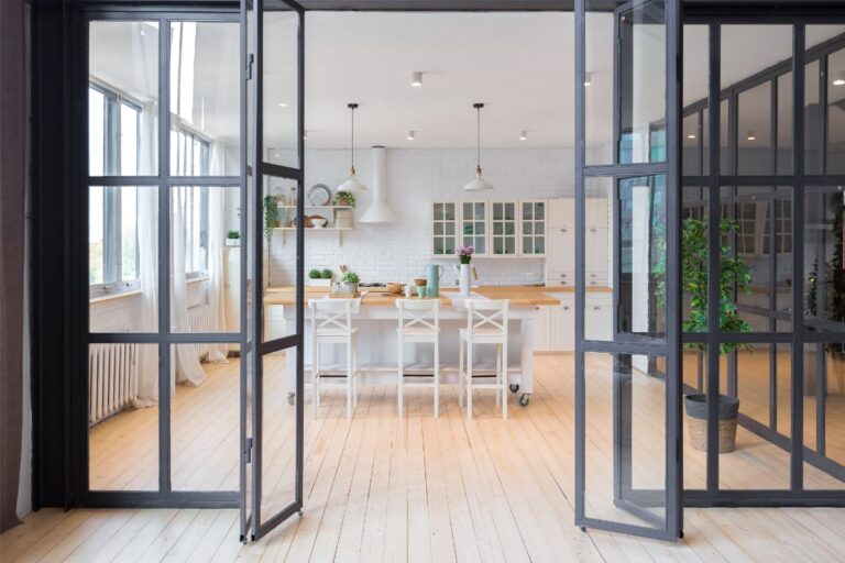Pohľad cez presklené skladacie dvere do jedálne a kuchyne.
