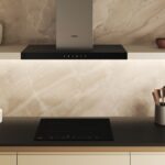 Moderná kuchynská linka s varnou doskou a moderným digestorom, ktorý je súčasťou otvorenej police.