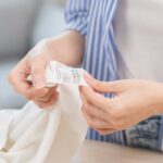 Žena pri kontrole štítku na oblečení.