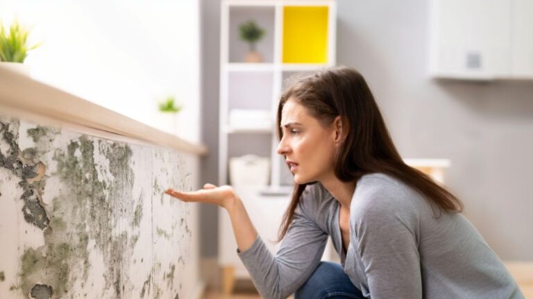 Žena sa díva na stenu s plesňami.