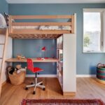 Detská izba s drevenou poschodovou posteľou, integrovaným bielym stolom a stenou vo farbe modrošedej.