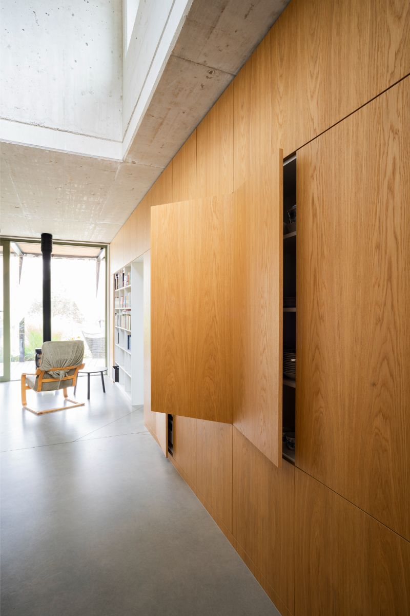 Zostava vstavaných skriniek na mieru spája dennú zónu od kuchyne až po knižnicu.