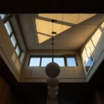 Vnútorný obytný priestor s pohľadovým betónovým stropom a horným pásovým oknom.