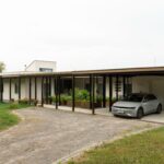 Krytá terasa prechádzajúca do prestrešeného parkovacieho miesta pri rodinnom dome.