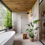 Kúpeľňa s vaňou, dreveným stropom, veľkými okennými tabuľami a interiérovými rastlinami.
