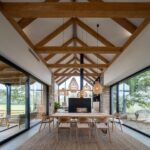 Otvorená denná zóna s jedálenským stolom pri dvoch presklených stenách a kozube.