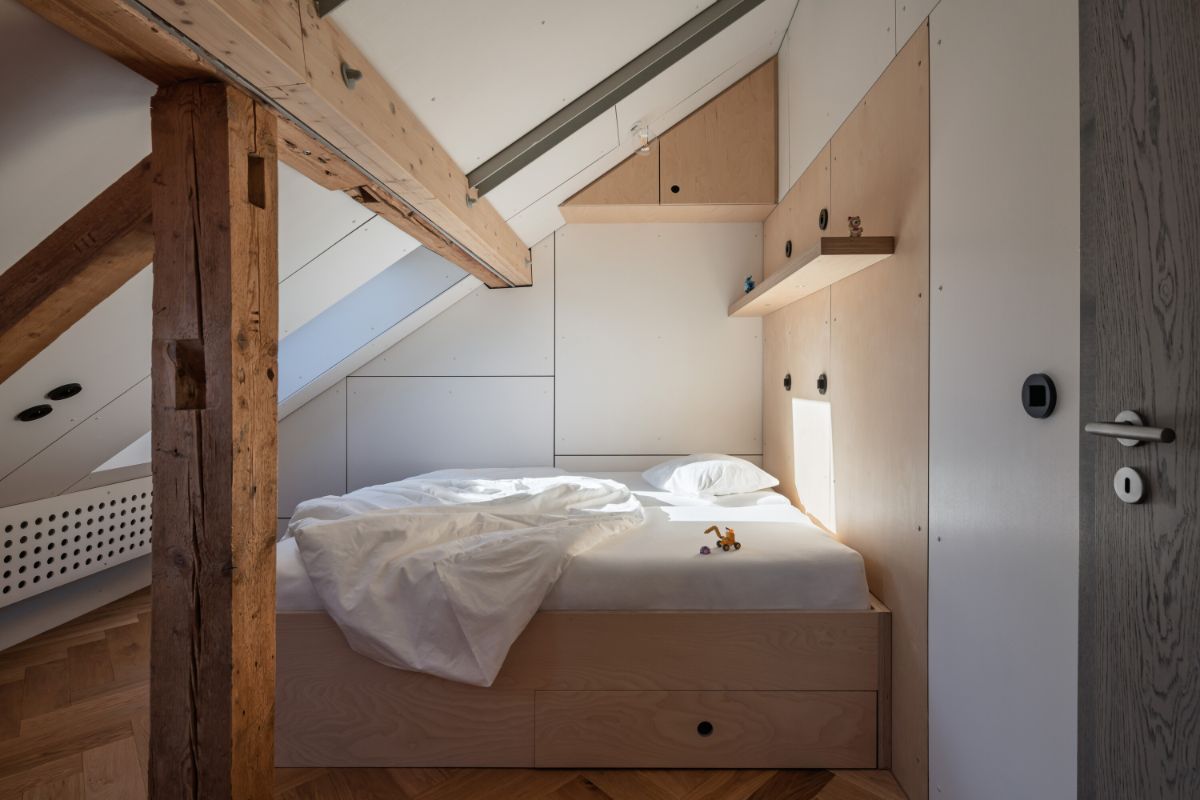 Znížený priestor pod zošikmenými stenami na prízemí využili architekti na umiestnenie postelí.