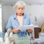 Staršia žena si vzdychla pri pohľade na dokumenty k rekonštrukcii.