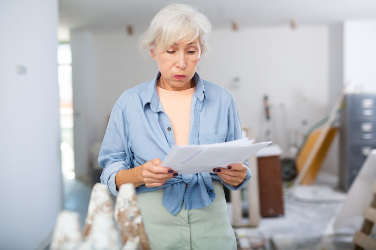Staršia žena si vzdychla pri pohľade na dokumenty k rekonštrukcii.