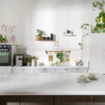 Kuchynská linka s otvorenými policami a ostrovčekom s mramorovou pracovnou doskou.