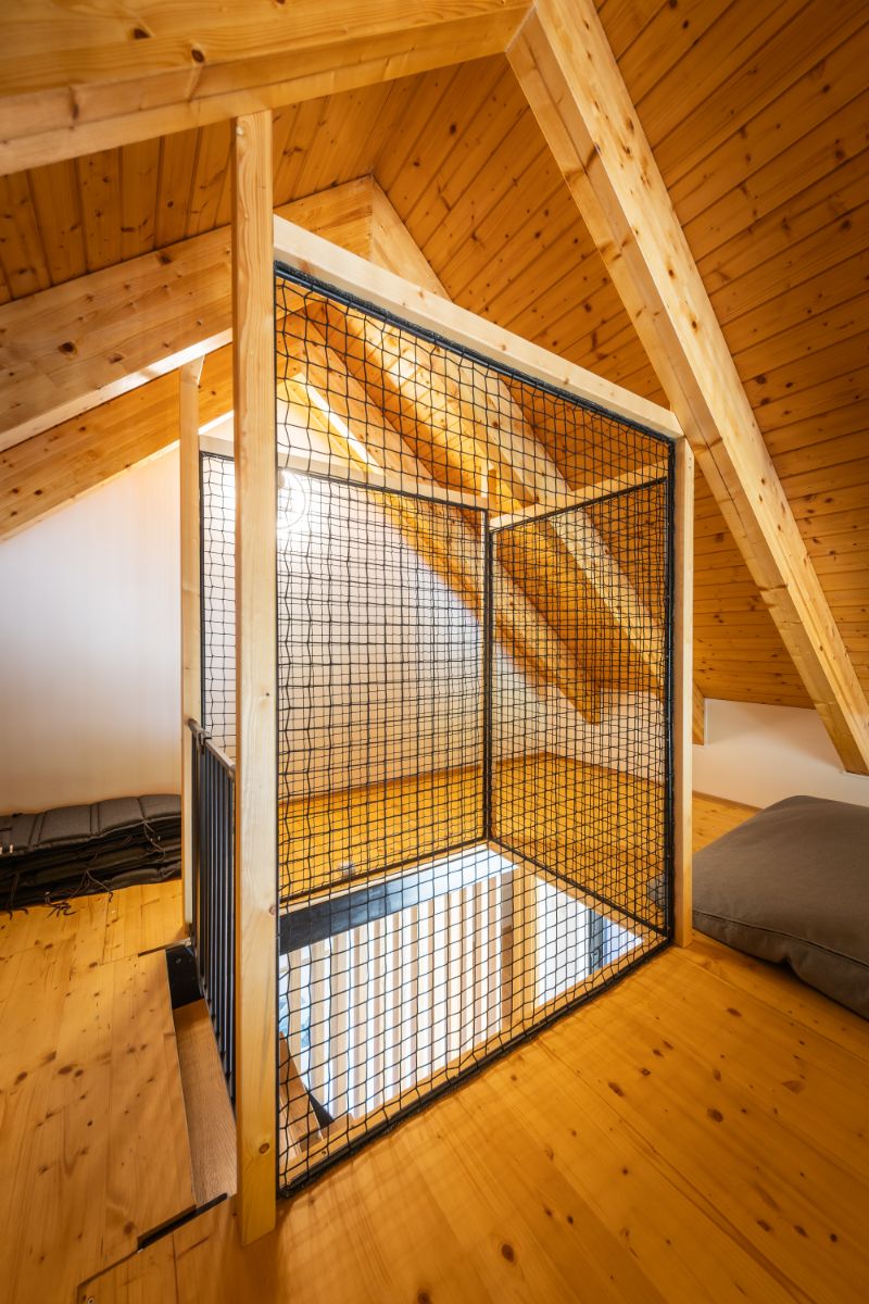 Takto vyzerá medziposchodie pod šikminou strechy. Uprostred je vstup po rebríku chránený sieťou.