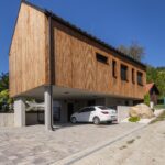 Chata na betónových stĺpoch s drevenou fasádou a sedlovou strechou,