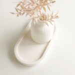 Biela váza na podnose na bielom podklade.