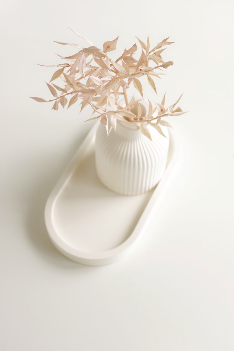 Biela váza na podnose na bielom podklade.