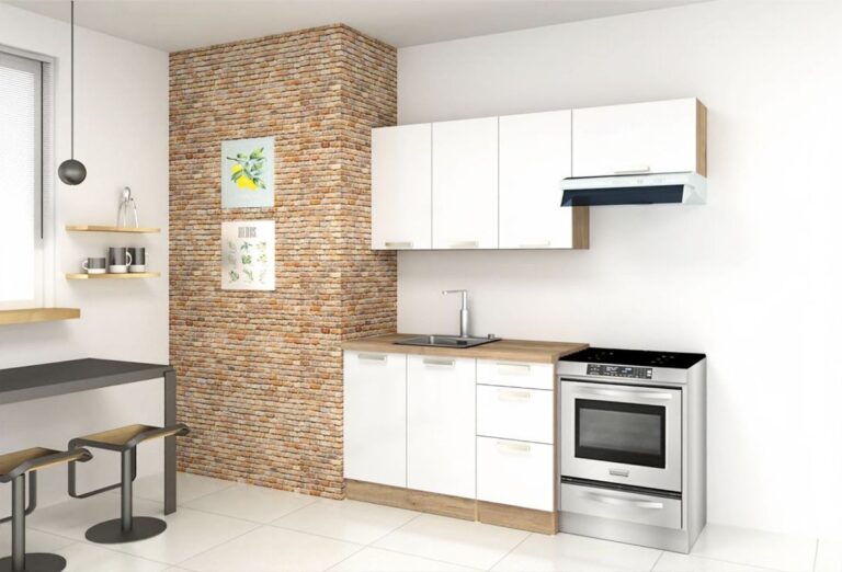 Moderná kuchynská linka v bielej farbe vedľa tehlou obloženého múra.