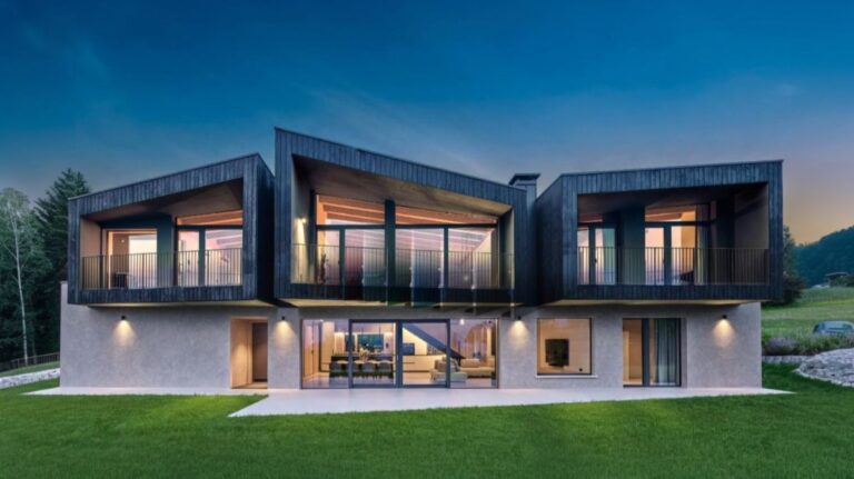Moderný dvojpodlažný dom s veľkoormátovým presklením a posuvnými dverami na balkóny a terasu.