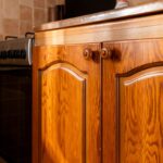 Dvierka staršej hnedej kuchynskej linky v drevenom dekore.