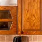 Horné kuchynské skrinky so presklenými časťami v hnedom dekore dreva.