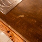 Tmavohnedá laminátová pracovná doska s poškodeným povrchom.