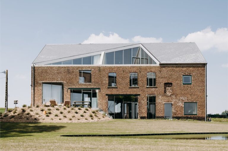 Rekonštrukcia tehlovej stodoly s modernou presklenou nadstavbou, hliníkovými rámami a rozľahlou trávnatou záhradou.