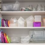 Skrinka s upratanými plastovými dózami a vrchnákmi.