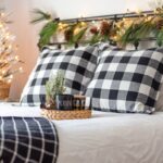 Posteľ s čierno-bielymi vankúšmi s vianočnou výzdobou.