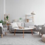 Interiér so sedacím nábytkom vo svetlosivých a bielych farbách.