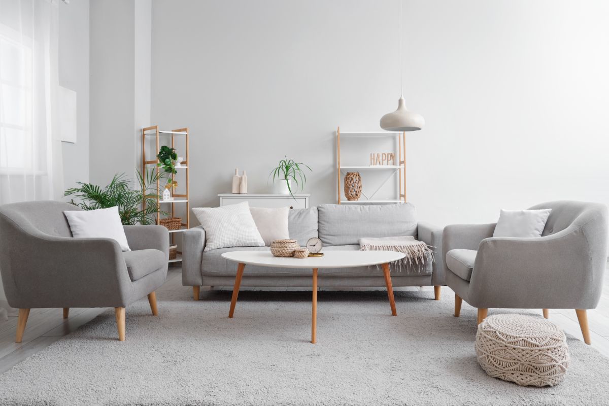 Interiér so sedacím nábytkom vo svetlosivých a bielych farbách.