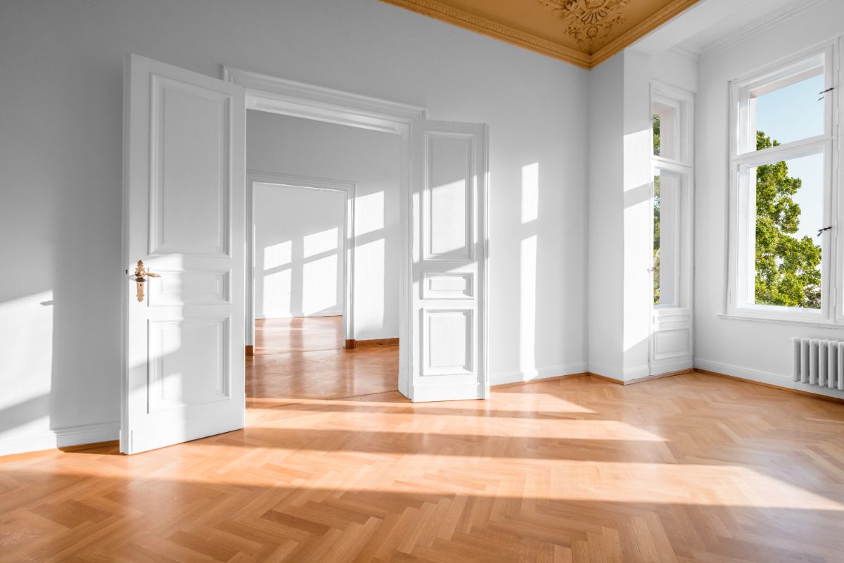 Interiér starého domu s parketovou podlahou a dvojkrídlovými dverami po rekonštrukcii.