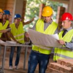 Skupina odborníkov na stavbe sa díva do dokumentov.