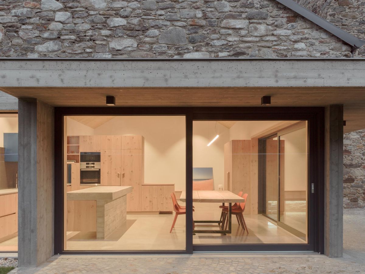 Veľkoformátové presklené dvere prepájajú interiér s pozemkom a prestrešenou terasou.