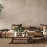 Nízka svetlohnedá sedačka pri rustikálnom stole a béžovej výraznej stierke.